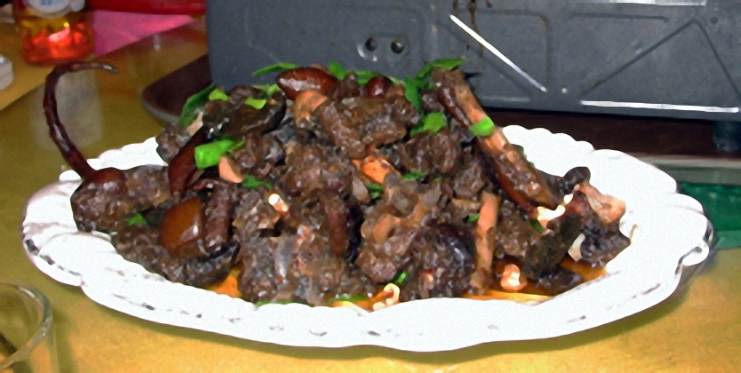 Gebratenes Hundefleischgericht, mit einem Hundeschweif als Dekoration (links)