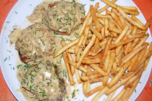 Drei Schweinerückensteaks mit viel Senf-Sauce und Pommes Frites