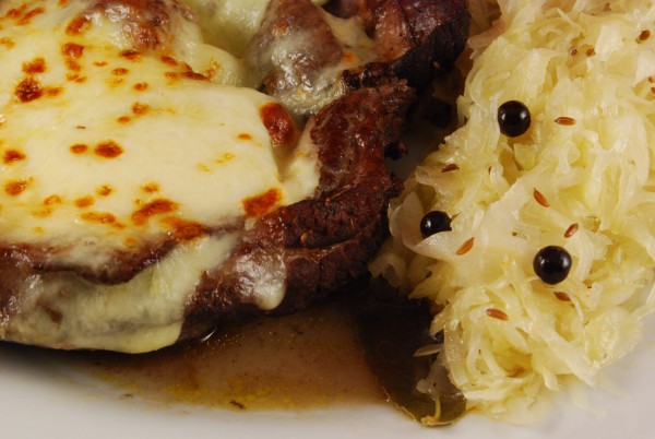 Mit Mozzarella überbackener Braten und Sauerkraut