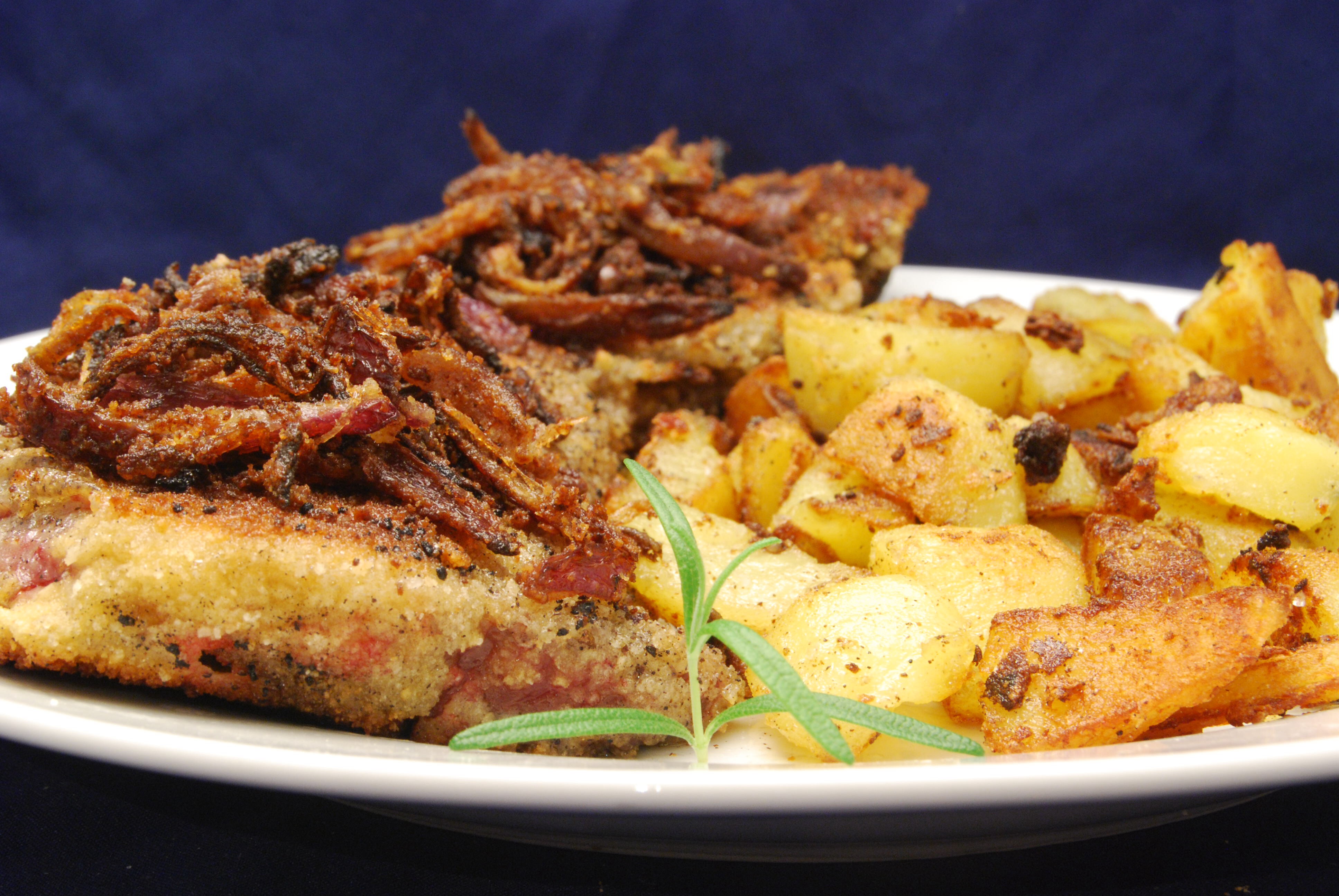 Paniertes Schweineherz mit Röstzwiebeln und Bratkartoffelwürfeln ...