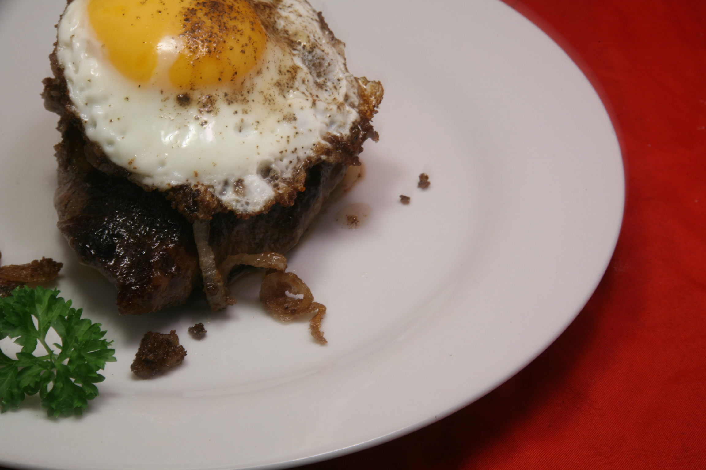 Pferde-Rumpsteak mit Röstzwiebeln, Kräuterbutter und Spiegelei