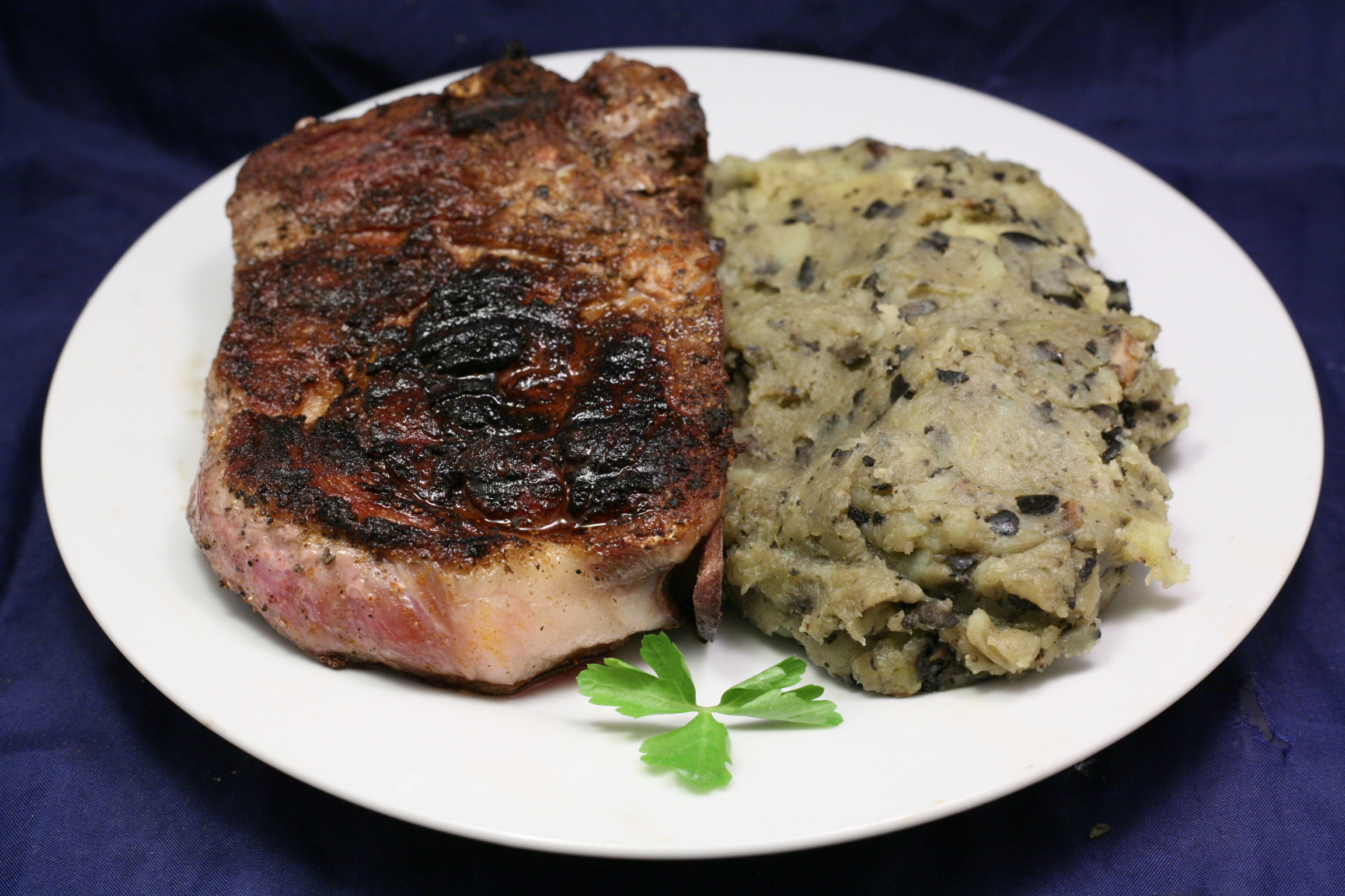 Schweine-Nackensteak mit Kartoffel-Oliven-Champignon-Stampf