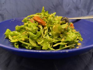 Rucola-Salat mit Gemüse, Oliven und Cheddar