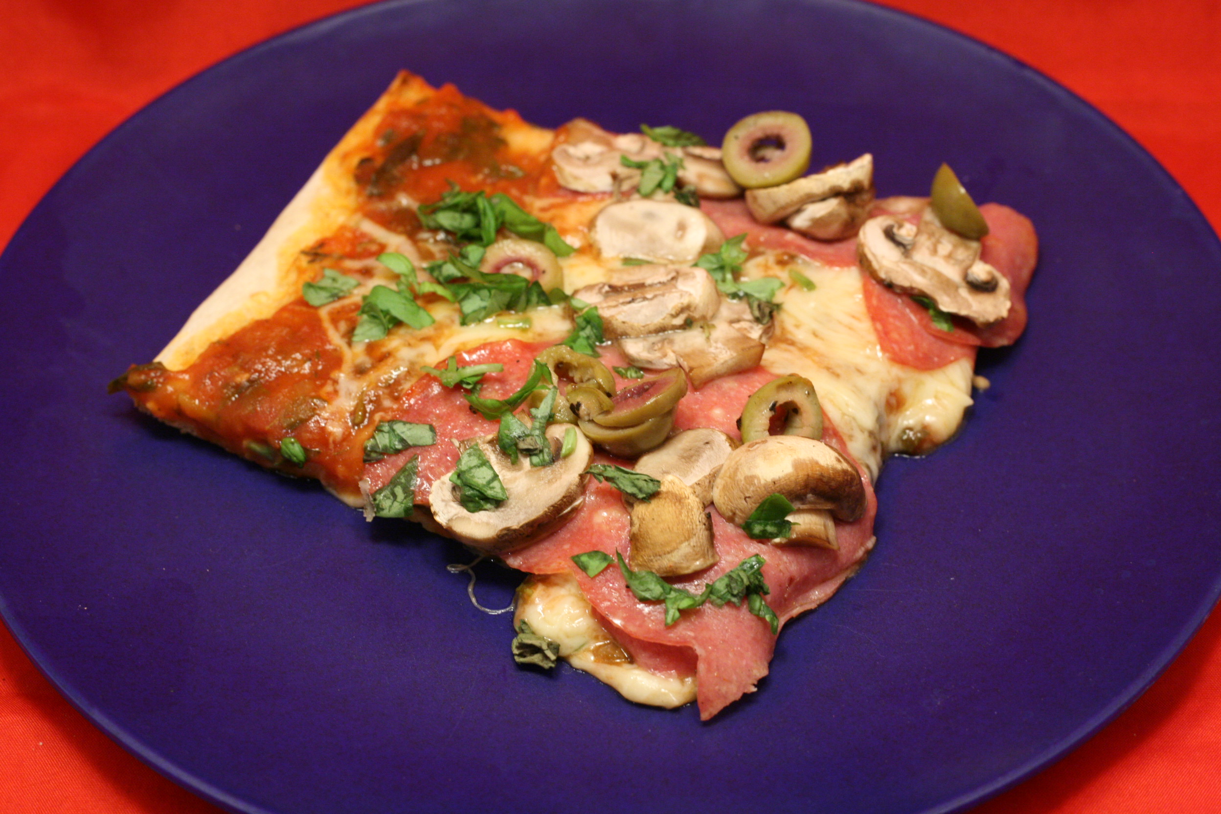 Pizza mit Salami, Champignons und Oliven