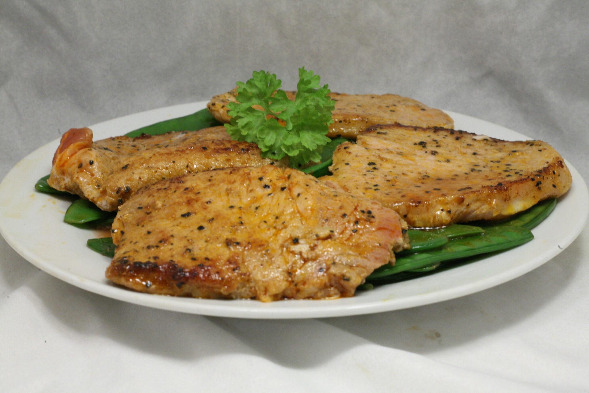 Marinierte Schweinesteaks auf Zuckerschotenbett Nudelheissundhos