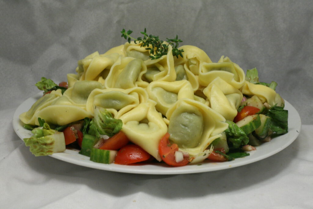 Tortellini mit Ricotta-Spinat-Füllung auf gemischtem Salat ...