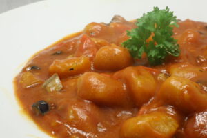 Kürbis-Gnocchi in Tomaten-Sauce mit Mini-Aubergine, Rispentomaten und Knoblauch