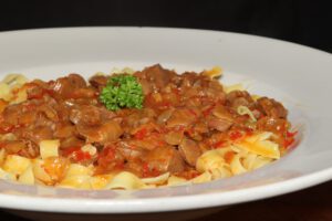 Hähnchenmägen-Gulasch in Chili-Bohnen-Sauce auf frischer Tagliatelle